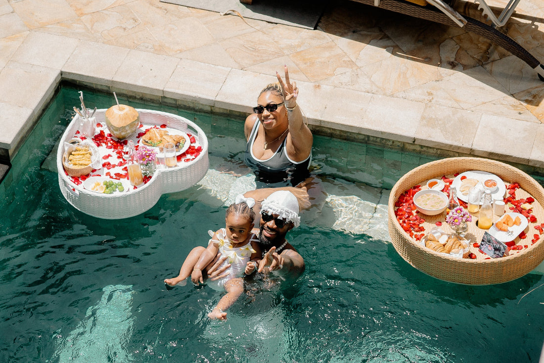 A couple with one kid enjoying floating breakfast in their villa pool in Bali