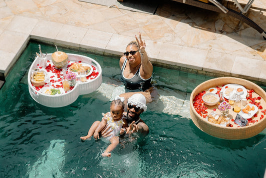 A couple with one kid enjoying floating breakfast in their villa pool in Bali