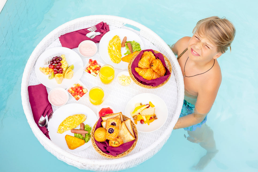 a boy holding a floating breakfast in a pool in bali enjoying vacation