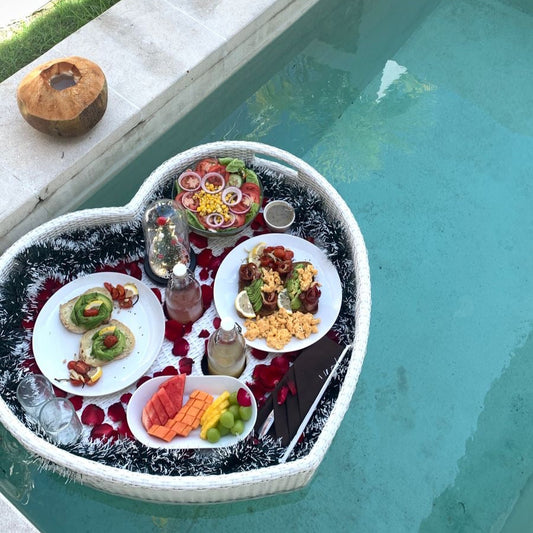 avocado toast with salad and fruits on a decorated floating basket in a pool villa in bali as a floating breakfast delivered by grazie bali