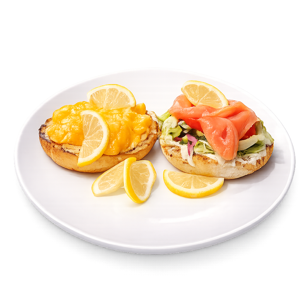 Two bagel sandwiches with different fillings on a white plate with lemon slices.